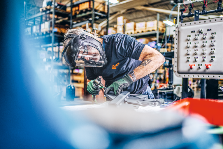 employeeweldingwithgreenglovesblurryblueforeground_buschamerika2022_481__300dpi_cmyk_edit